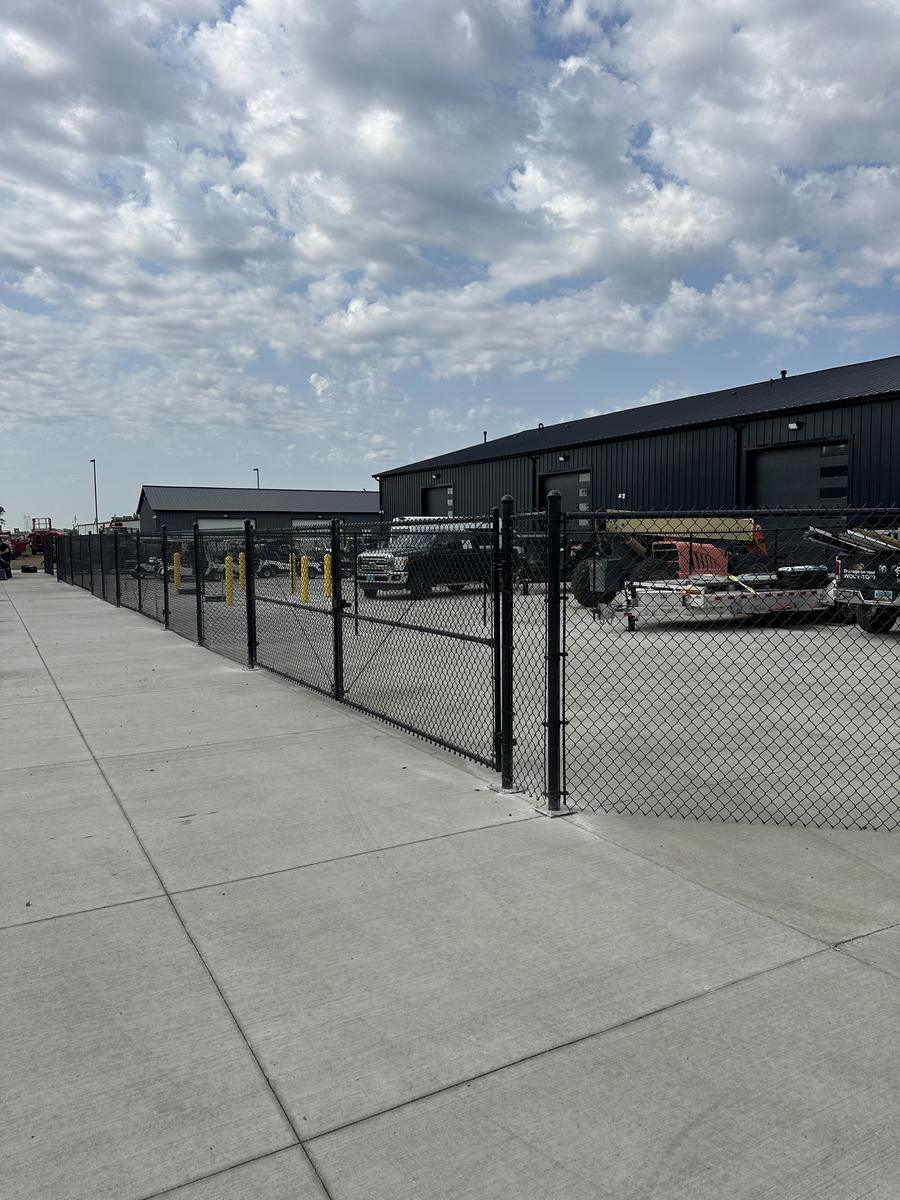 Industrial chain link fencing along a facility