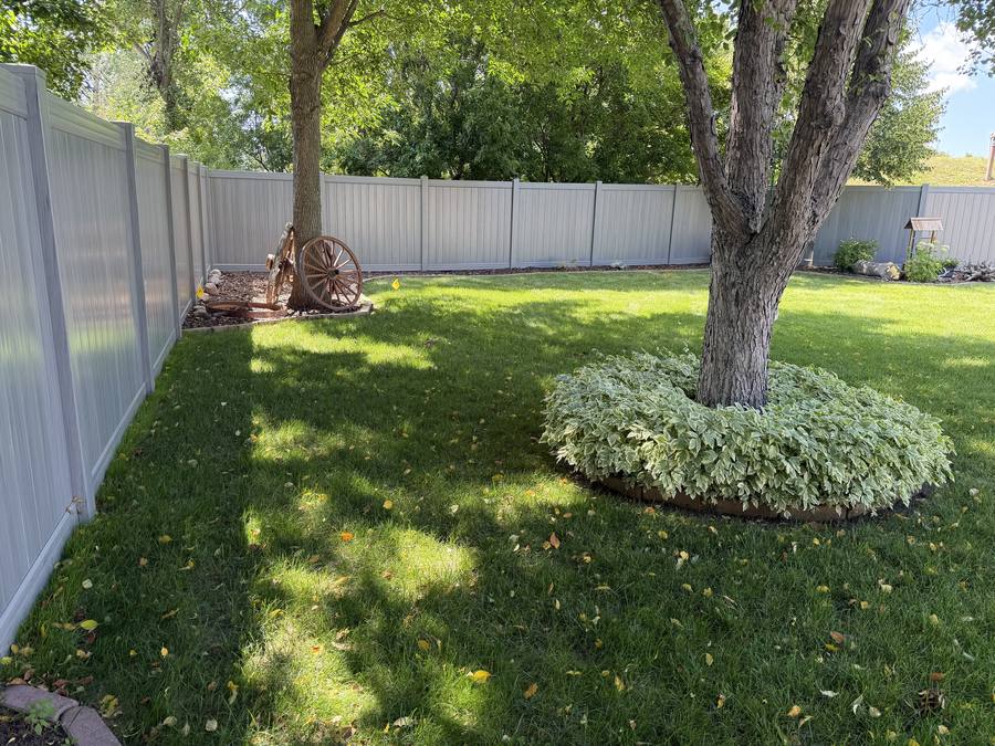 White vinyl privacy fence with tree